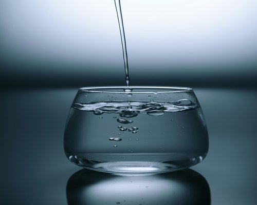 A glass of fresh water reflecting natural light